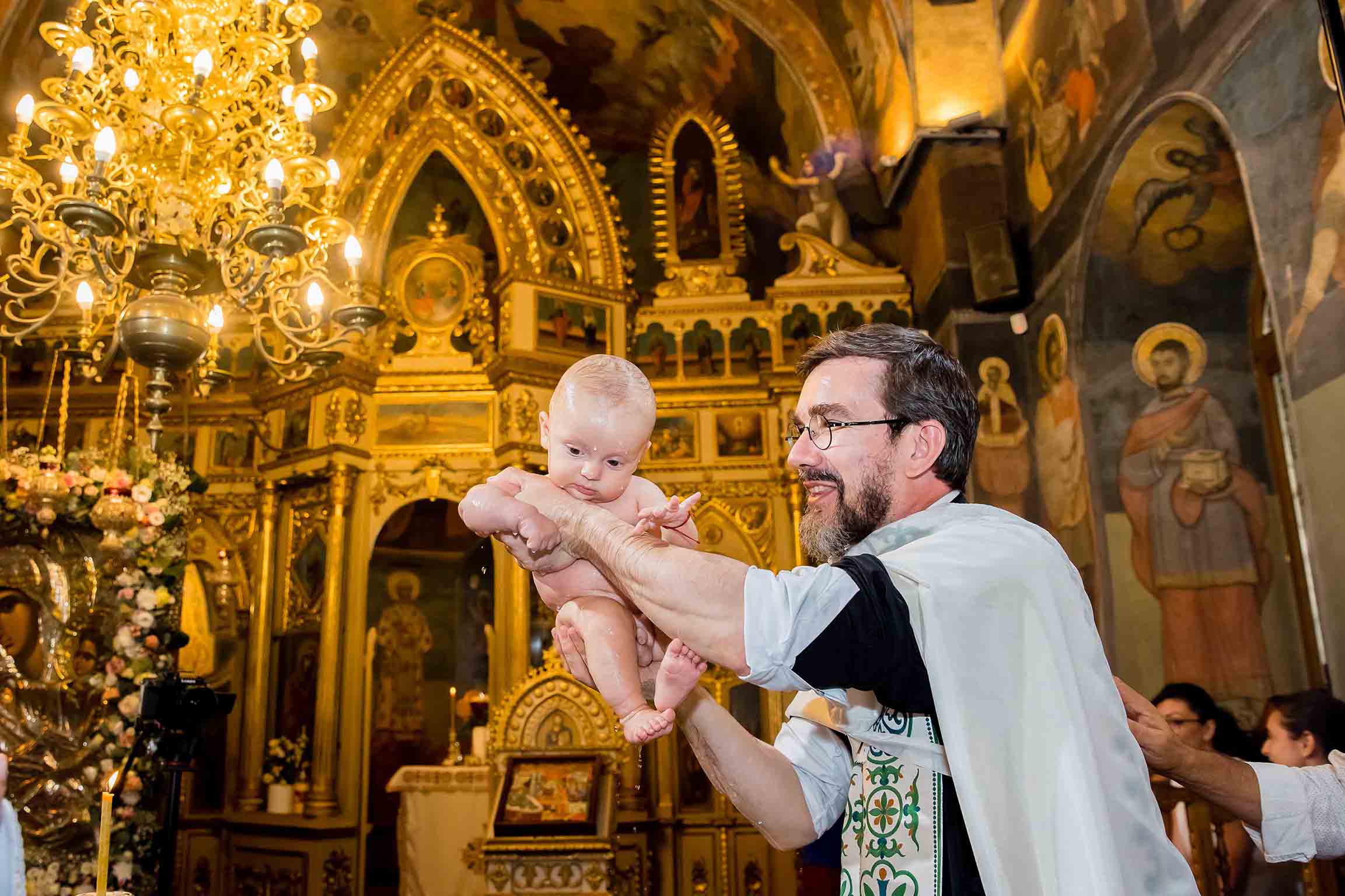 preot cu copil in brate la botez